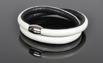 Armbånd i hvid lak læder og sort kalveskind. 2 omgange med magnetlås i stål. Tykkelse 7,5 mm.